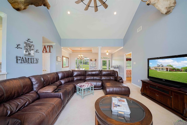 living area featuring decorative columns, visible vents, high vaulted ceiling, a chandelier, and light carpet