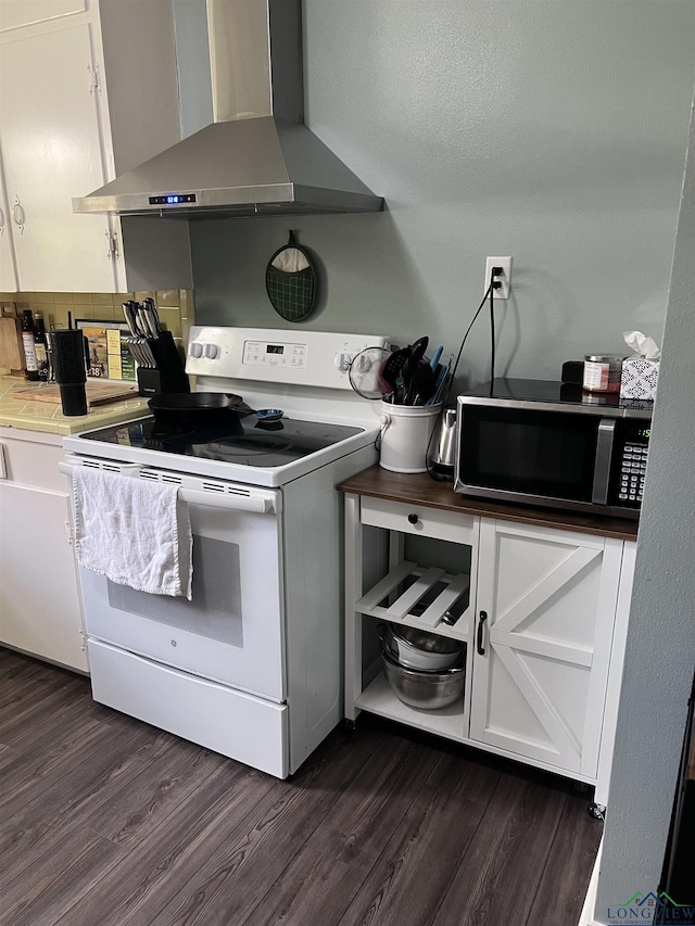 204 Mount Sylvan St, Lindale, TX 75771 - kitchen featuring wall chimney range hood, white range with electric stovetop, stainless steel microwave, dark wood-style flooring, and white cabinets