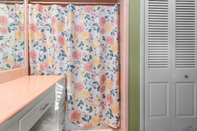 bathroom featuring vanity and curtained shower