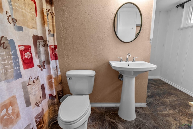 bathroom featuring a shower with curtain and toilet