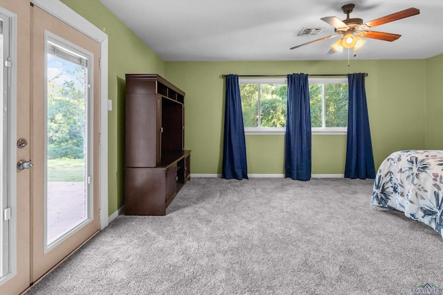 carpeted bedroom with multiple windows, access to outside, and ceiling fan