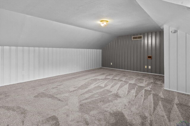 bonus room featuring carpet floors, a textured ceiling, and vaulted ceiling