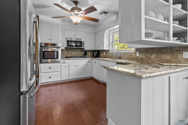 kitchen featuring white cabinets, ceiling fan, dark hardwood / wood-style floors, appliances with stainless steel finishes, and light stone counters