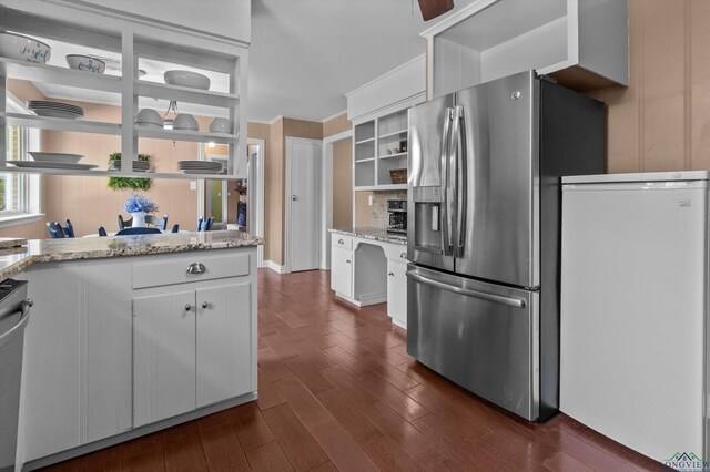 kitchen featuring dark hardwood / wood-style floors, light stone counters, white cabinetry, and stainless steel appliances