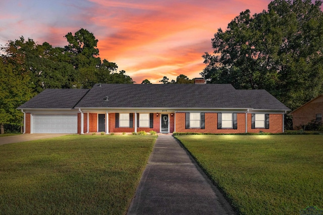 ranch-style house featuring a yard and a garage