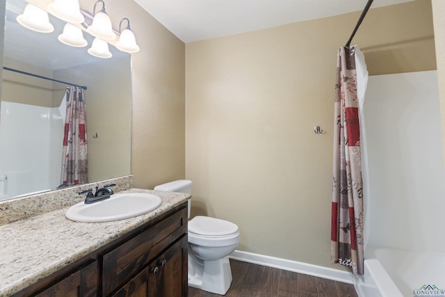 1130 Oakwood St, Carthage, TX 75633 - bathroom featuring baseboards, wood finished floors, vanity, toilet, and shower / bath combo
