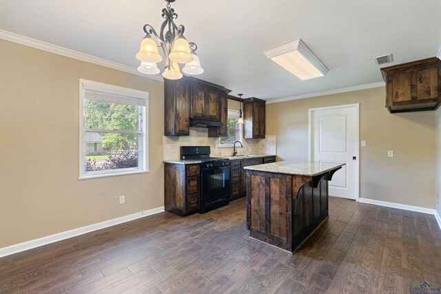 1130 Oakwood St, Carthage, TX 75633 - kitchen featuring black gas stove, under cabinet range hood, a sink, a chandelier, and dark brown cabinetry