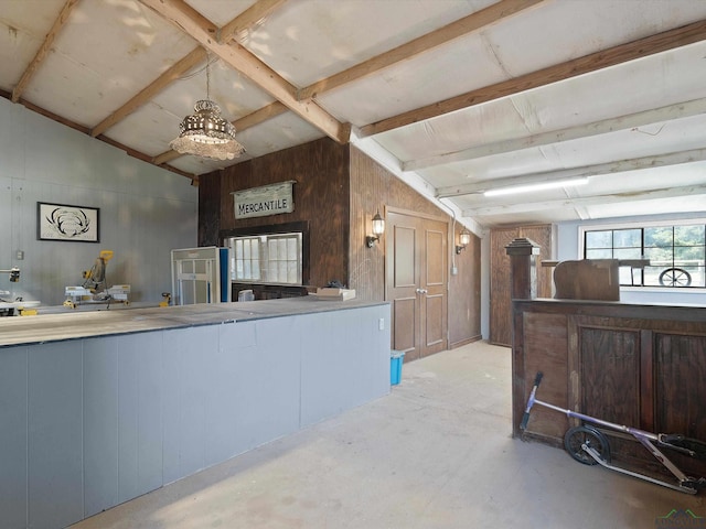 kitchen with vaulted ceiling and wooden walls