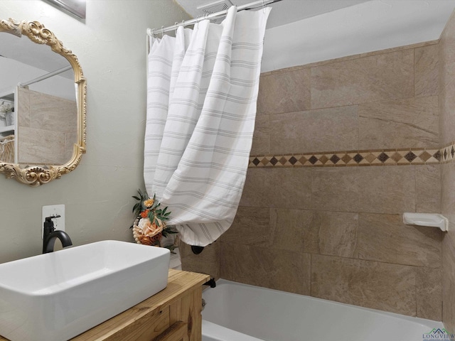 bathroom with shower / bathtub combination with curtain and sink