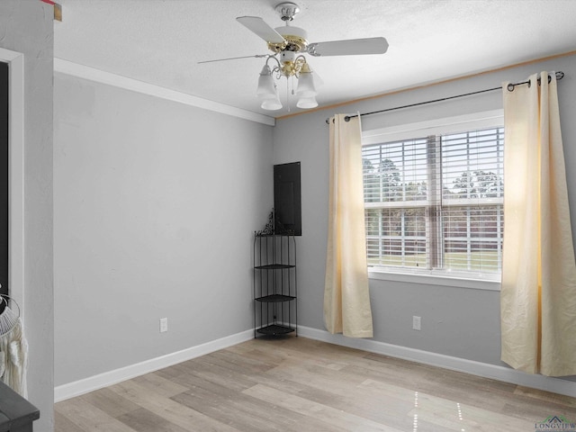 unfurnished room featuring ceiling fan, light hardwood / wood-style floors, and ornamental molding