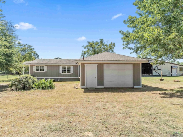 exterior space featuring a garage, an outdoor structure, and a front yard