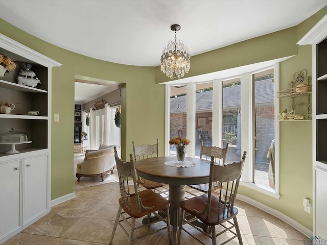 dining space featuring built in features, light tile patterned floors, and an inviting chandelier