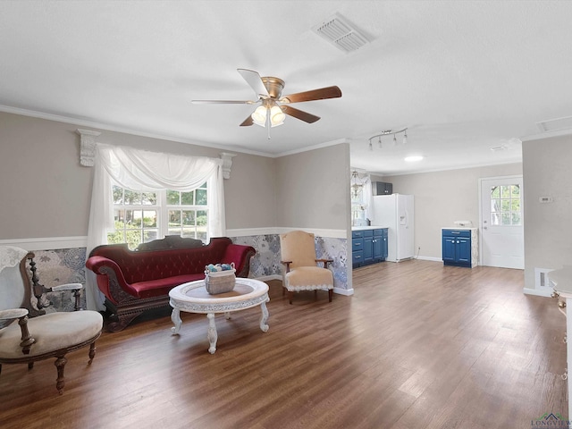 living room featuring crown molding, dark hardwood / wood-style flooring, ceiling fan, and a healthy amount of sunlight