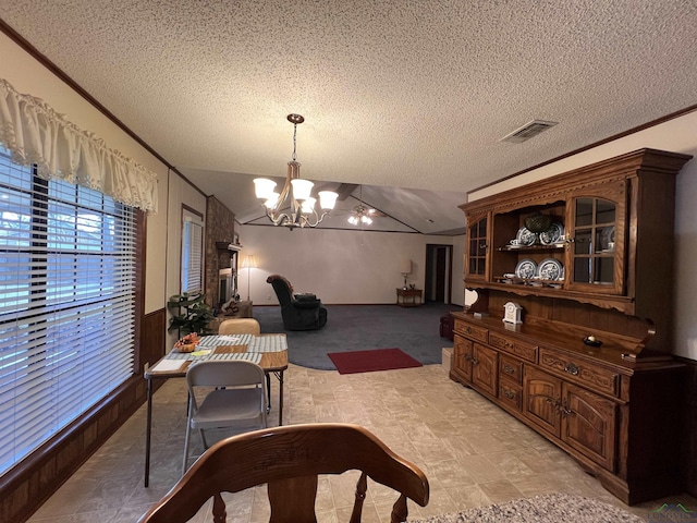 dining area featuring a textured ceiling, ornamental molding, vaulted ceiling, and a notable chandelier