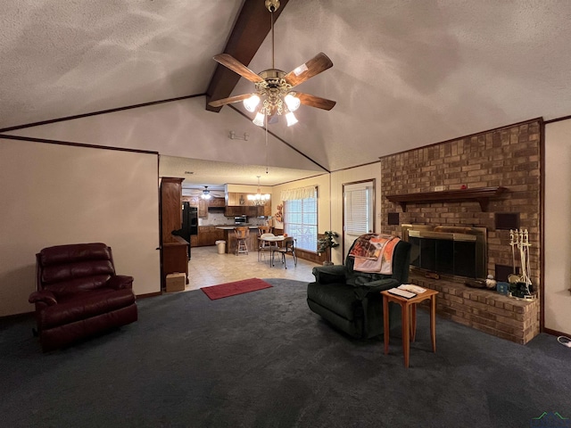 carpeted living room with a textured ceiling, vaulted ceiling with beams, a fireplace, and ceiling fan with notable chandelier