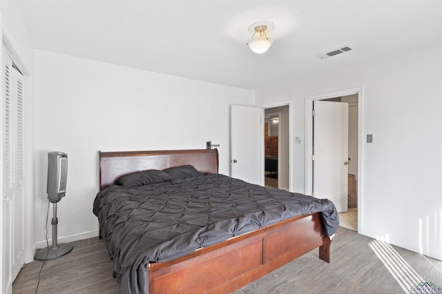 bedroom with visible vents and wood finished floors