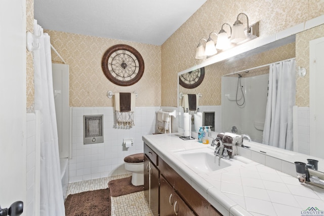 bathroom featuring tile patterned flooring, tile walls, vanity, wainscoting, and wallpapered walls