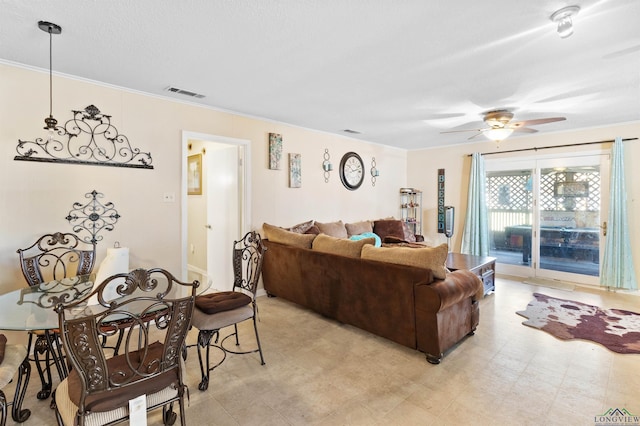 living area with visible vents, light floors, ornamental molding, and a ceiling fan