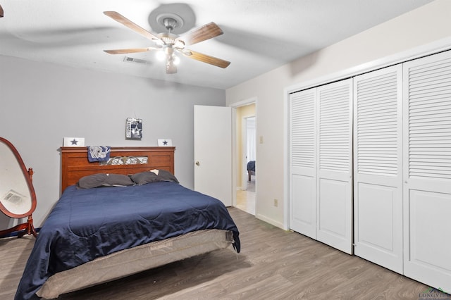 bedroom featuring ceiling fan, visible vents, baseboards, a closet, and light wood-type flooring