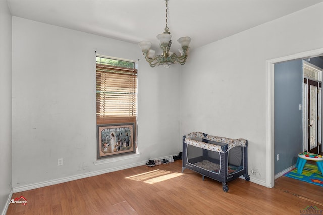 spare room featuring a chandelier and hardwood / wood-style flooring