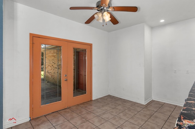 tiled empty room featuring ceiling fan and french doors