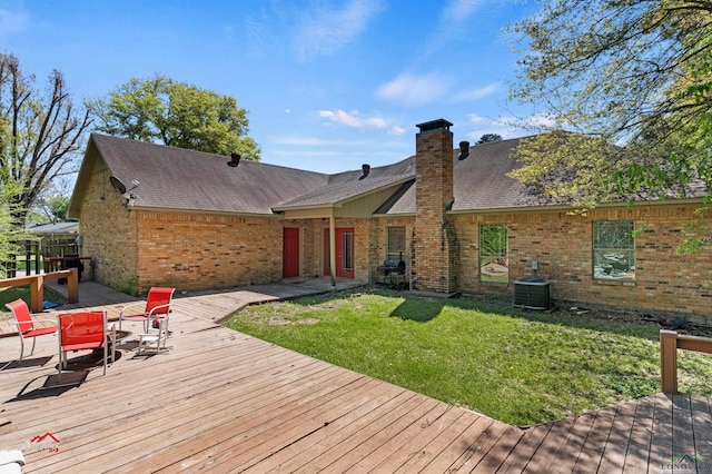 rear view of property with central AC, a deck, and a lawn