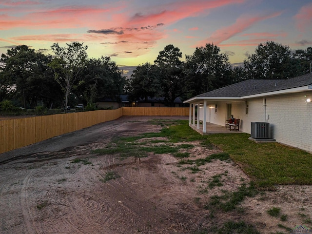 yard at dusk featuring a patio and cooling unit