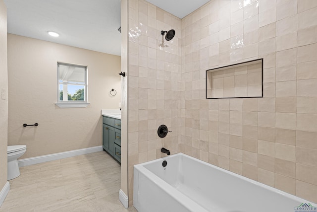 full bathroom with tiled shower / bath, vanity, and toilet