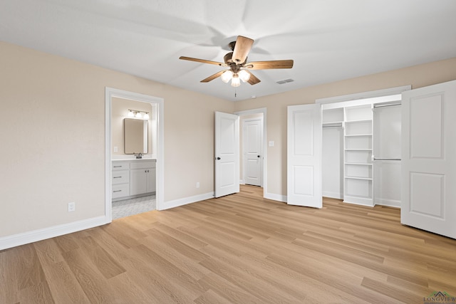 unfurnished bedroom with ensuite bathroom, ceiling fan, sink, light hardwood / wood-style flooring, and a closet