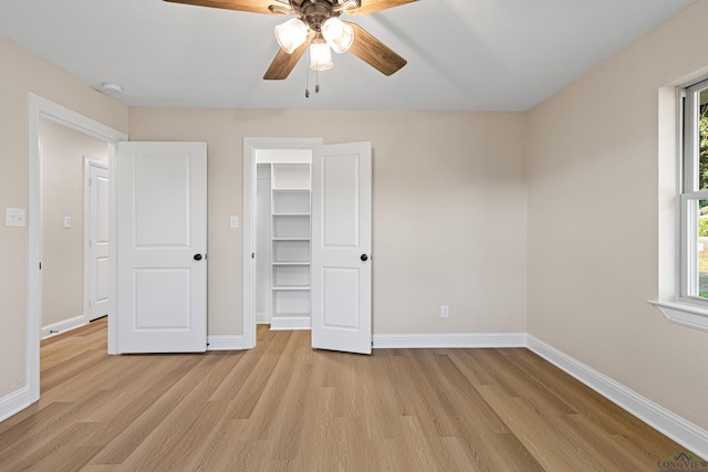 unfurnished bedroom with ceiling fan, light hardwood / wood-style floors, a spacious closet, and a closet