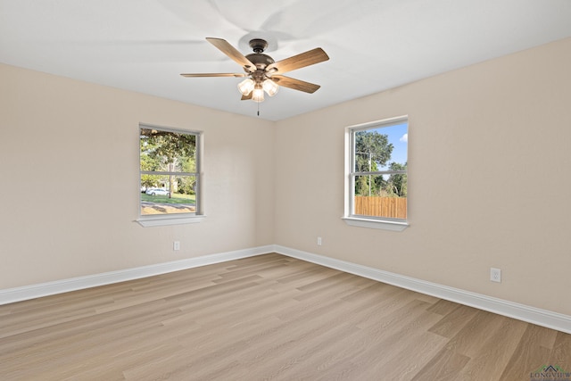 spare room featuring a wealth of natural light, light hardwood / wood-style flooring, and ceiling fan