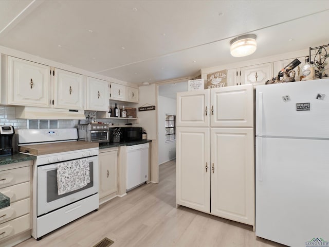 3065 E Lake, Gladewater, TX 75647 - kitchen with white appliances, under cabinet range hood, dark countertops, and white cabinetry