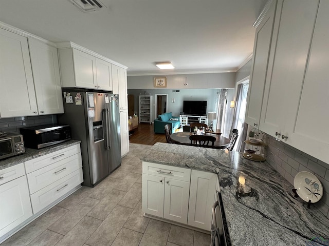 kitchen with white cabinetry, light stone counters, and stainless steel appliances