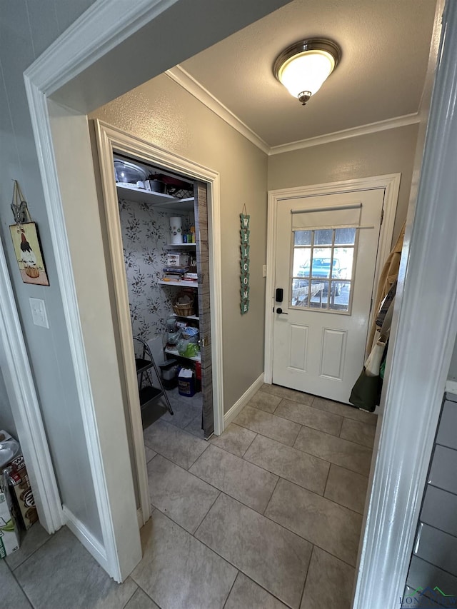 doorway with ornamental molding and light tile patterned floors