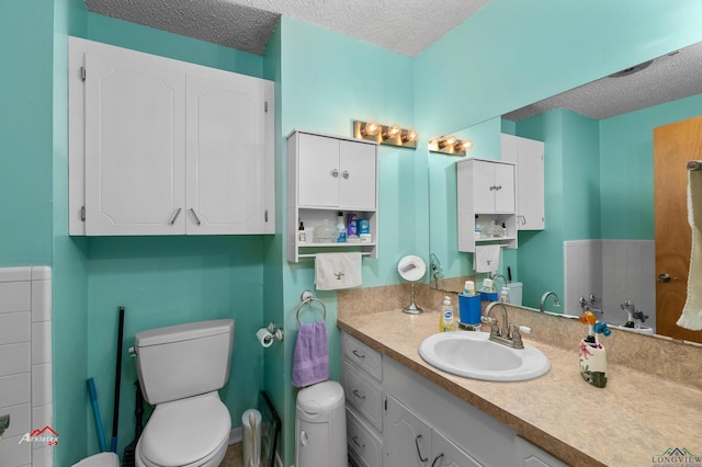 bathroom with vanity, a textured ceiling, and toilet