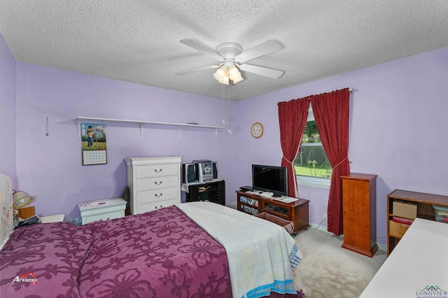 carpeted bedroom featuring ceiling fan and a textured ceiling