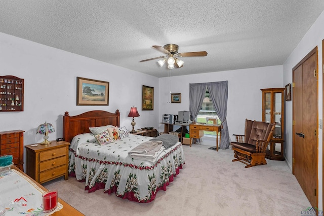 carpeted bedroom featuring a textured ceiling and ceiling fan