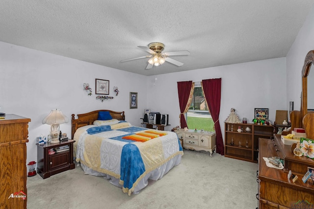 bedroom featuring light carpet, a textured ceiling, and ceiling fan