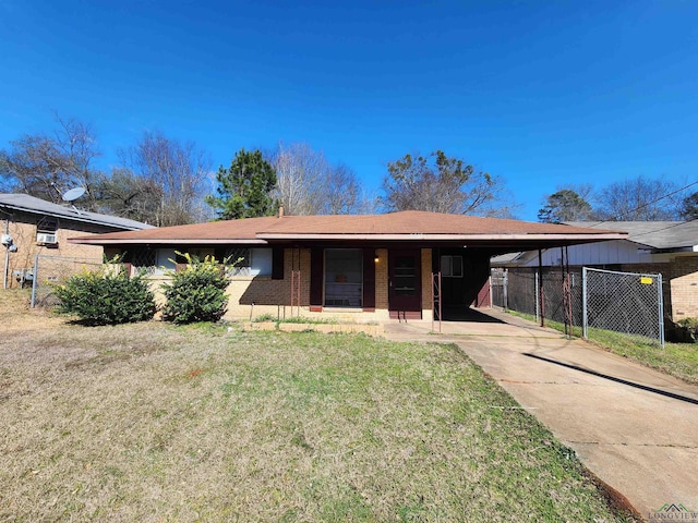 ranch-style home with brick siding, concrete driveway, a front yard, fence, and a carport