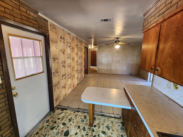 kitchen featuring a ceiling fan, light countertops, crown molding, and visible vents