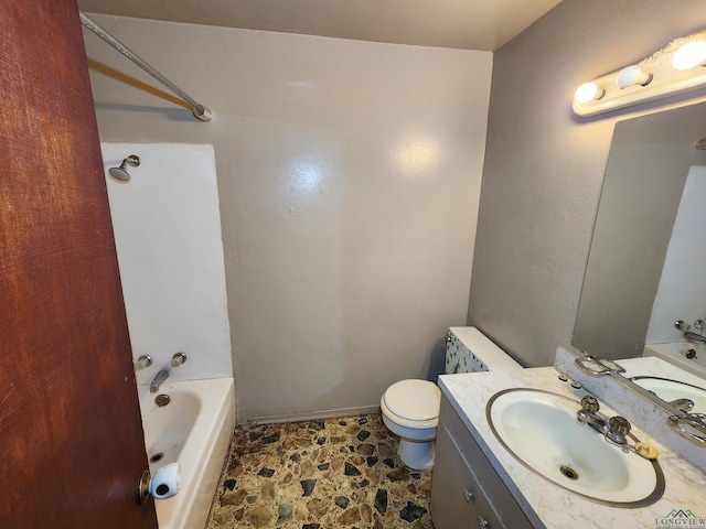 full bathroom featuring toilet, stone finish flooring, and vanity