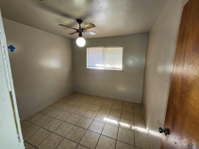 spare room with a ceiling fan and light tile patterned flooring