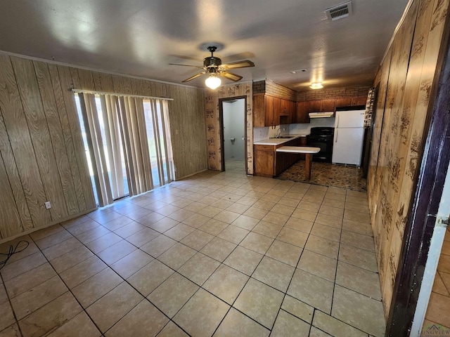 kitchen with visible vents, open floor plan, freestanding refrigerator, light countertops, and under cabinet range hood