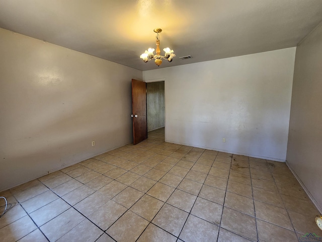 empty room featuring light tile patterned floors, visible vents, and a chandelier