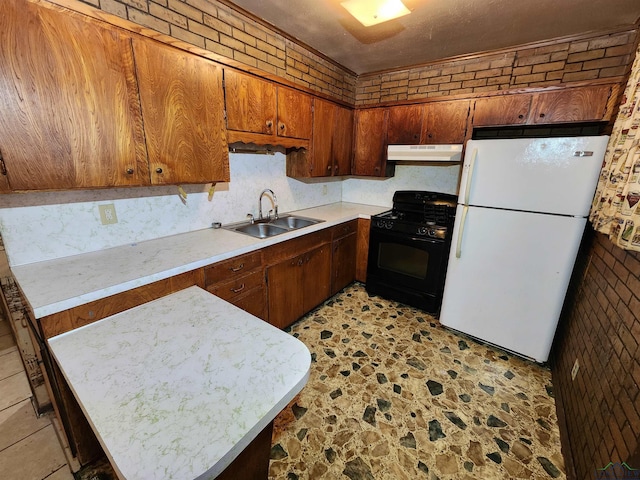 kitchen with light countertops, freestanding refrigerator, black range with gas cooktop, a sink, and under cabinet range hood