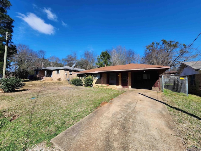 ranch-style home featuring concrete driveway, a front yard, and fence