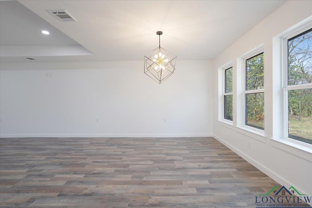 unfurnished dining area with hardwood / wood-style flooring and a chandelier