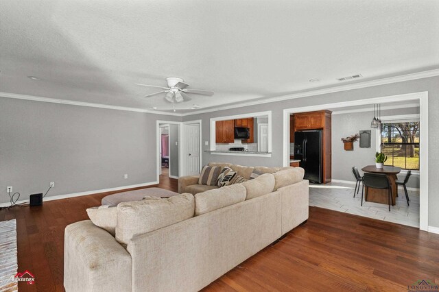 living room with ceiling fan, crown molding, a textured ceiling, and hardwood / wood-style flooring