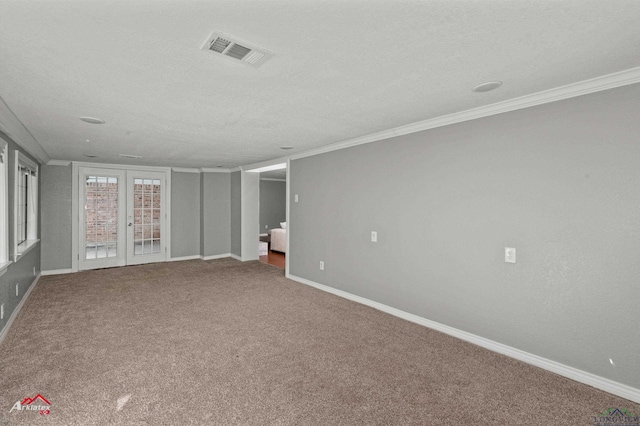 carpeted empty room with crown molding, french doors, and a textured ceiling