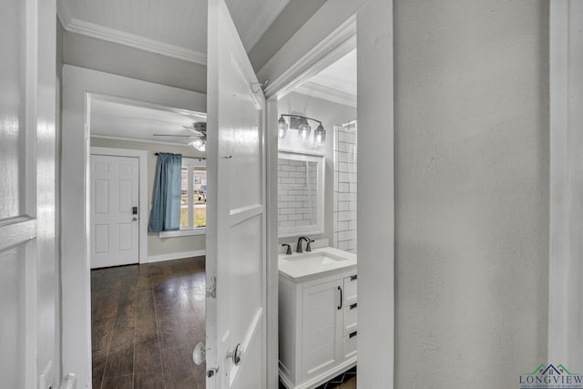 bathroom featuring hardwood / wood-style flooring, ornamental molding, vanity, and ceiling fan